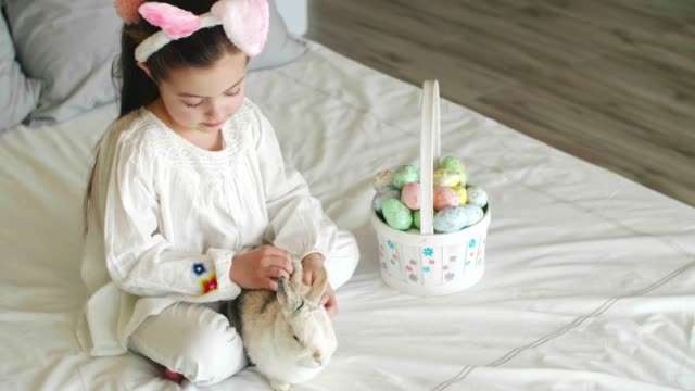 Kind-und-Kaninchen-verbringen-Ostermorgen-im-Bett