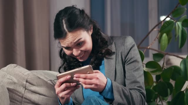 Excited-businesswoman-playing-game-on-mobile-phone
