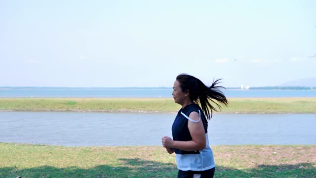 Eine-fette-asiatische-Frau,-die-morgens-im-natürlichen-Sonnenlicht-joggt.
Sie-versucht,-mit-Übung-Gewicht-zu-verlieren.--Konzept-Gesundheit-mit-Bewegung.
