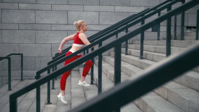 Plus-Größe-gemischte-Rasse-blond-lächelnde-Frau-Jogger-trägt-rote-Sportbekleidung-laufen-schnell