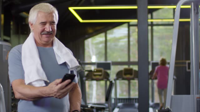 Old-Man-nutzt-Telefon-in-Gym