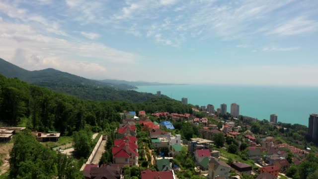 Aerial-video-shooting.-Flying-over-a-residential-area.-The-city-resort-of-Sochi.-Black-sea-coast.-Green-forest-and-mountains-by-the-sea.
