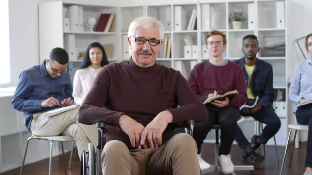Retrato-de-profesor-sentado-en-silla-de-ruedas-en-aula