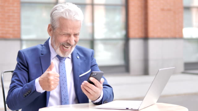 Old-Businessman-Excited-for-Success-on-Phone