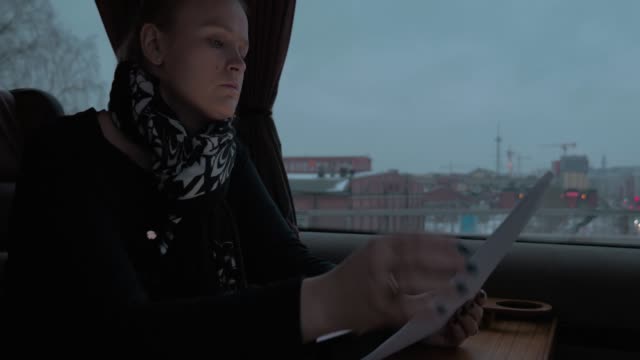 Mujer-en-tren-trabajando-con-documentos-y-tablet-PC