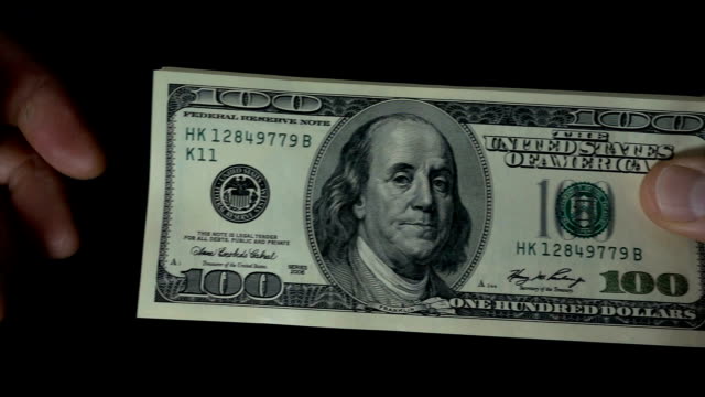 Slow-motion-of-a-hand-giving-a-dollar-bill-in-another-hand