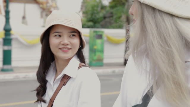 Glückliche-asiatische-lesbische-Paare-zu-Fuß-auf-der-Straße-genießen-Reisen-in-Thailand.-Schöne-junge-Frauen-mit-Spaß-in-der-Ferienzeit.-LGBT-Konzept.
