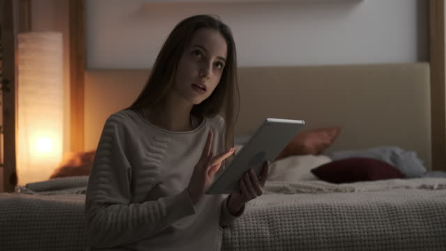Adolescente-chica-usando-tableta-digital-en-el-dormitorio-por-la-noche