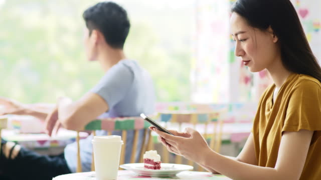 Handheld-Ansicht-der-vietnamesischen-Frau-mit-Handy-im-Café