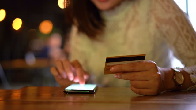 Joven-mujer-asiática-comprando-en-el-teléfono-móvil-con-pago-con-tarjeta-de-crédito