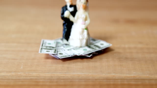Miniatur-Brautpaar-auf-Dollar-gehalten
