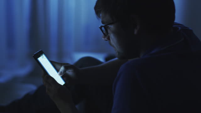 Mann-Browsing-Internet-auf-Telefon-bei-Nacht