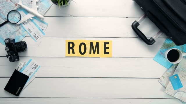 Draufsicht-Zeitraffer-Hände-auflegen-weißen-Schreibtisch-Wort,-das-"Rom"-mit-Reisen-Gegenständen-dekoriert