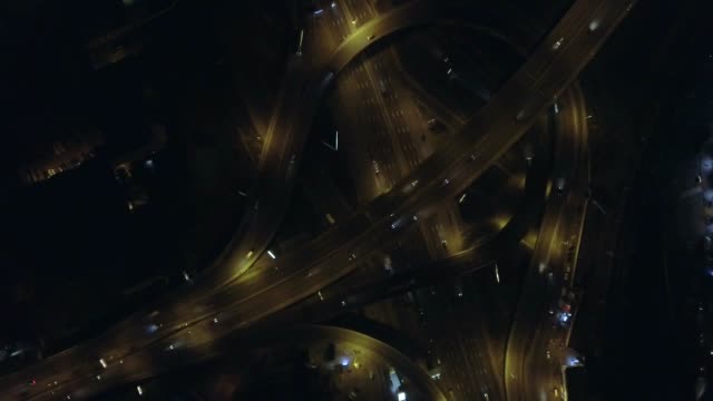 vertical-top-down-aerial-view-of-traffic-on-freeway-interchange-at-night