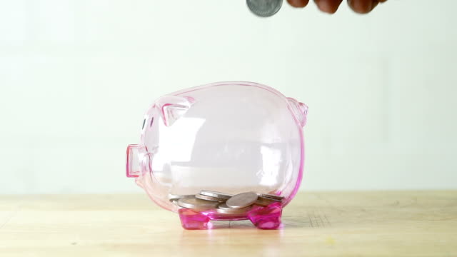concept-saving-money-for-buy-car-in-the-future,-closeup-of-hand-inserting-coin-money-into-piggy-bank