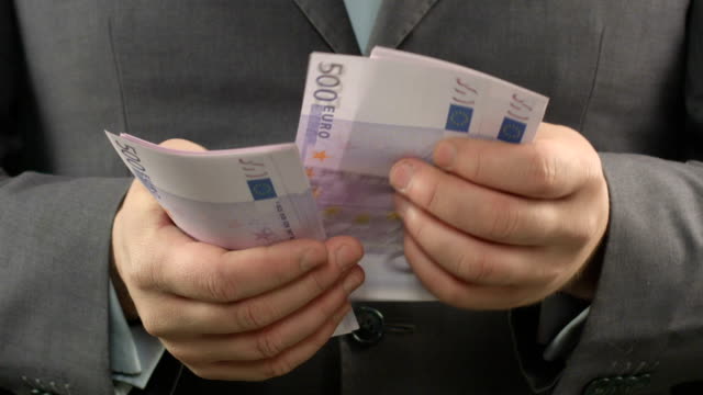 Hombre-en-traje-gris-contando-euros,-cerca-de-las-manos-del-empresario-con-dinero-en-efectivo