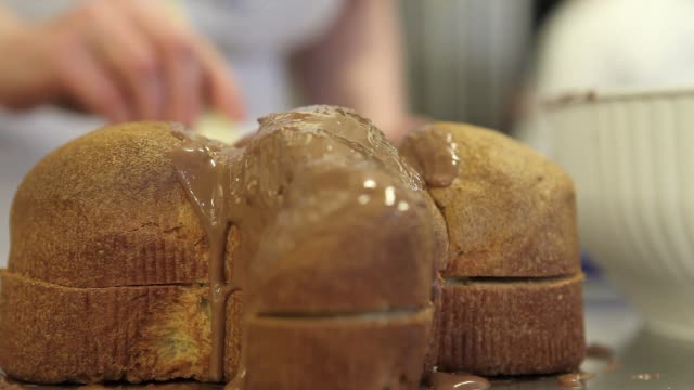 Pastry-Chef-Hände-glasiert-Osterkuchen-süßes-Brot-mit-Schokolade,-Nahaufnahme-auf-der-Arbeitsplatte-in-der-Konditorei