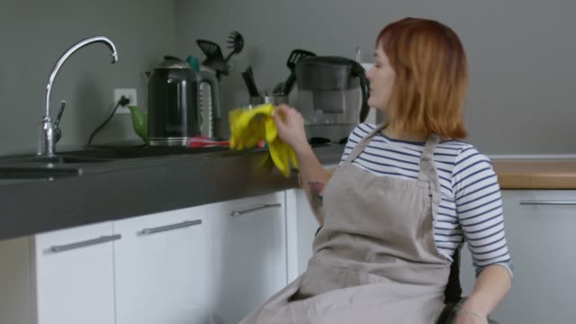 Stets-gut-gelaunte-Frau-im-Rollstuhl,-die-Hausarbeit