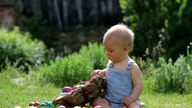 Niedlichen-Kind,-spielt-mit-kleinen-Häschen-und-Ostern-Eier-in-einen-blühenden-Garten,-Frühling.-Junge-mit-Kaninchen-spielen,-Ei-Jagd-für-Urlaub
