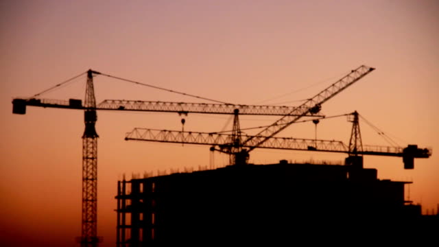 Bau-des-Hochhauses-gegen-auf-dem-Hintergrund-des-Sonnenaufgangs,-Zeitraffer