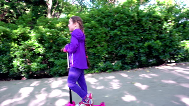 Kleines-Kind-einen-Roller-in-einem-Stadtpark-fahren-zu-lernen