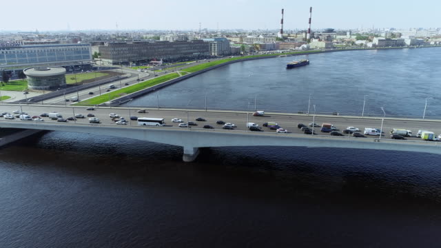 Brücke-über-den-großen-Fluss-mit-blauem-Wasser-und-Barge-pullin-in-der-Großstadt
