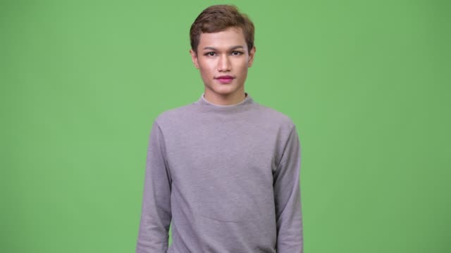 Happy-young-androgynous-Asian-man-with-arms-crossed