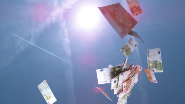 SLOW-MOTION-CLOSE-UP:-Fifty-and-hundred-euro-€-bills-falling-from-the-blue-sky