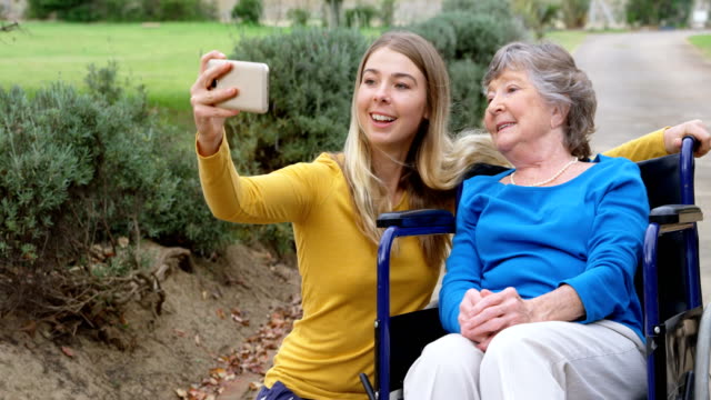 Senior-mujer-y-chica-joven-tomando-selfie-4k