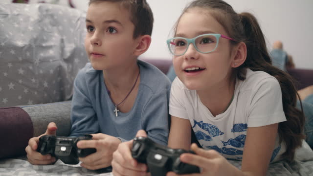 Niños-jugando-juegos-de-video.-Acostado-en-el-sofá-con-el-regulador-en-manos-de-los-niños