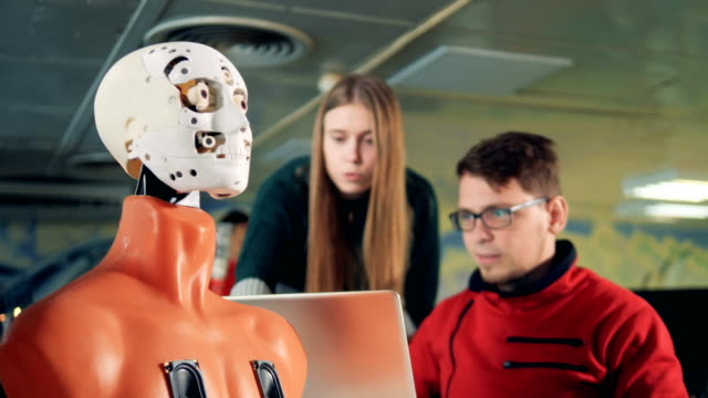 Robot-is-made-to-wink-by-a-male-and-a-female-specialists-by-means-of-a-computer