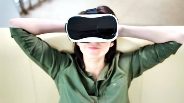 Mittlere-Nahaufnahme-Frau-trägt-moderne-Virtual-Reality-Maske-und-entspannend