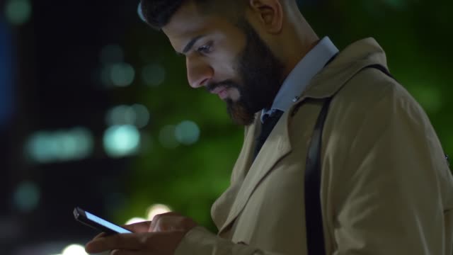 Junger-Geschäftsmann-aus-dem-Nahen-Osten-beantwortet-Nachrichten-auf-Smartphone