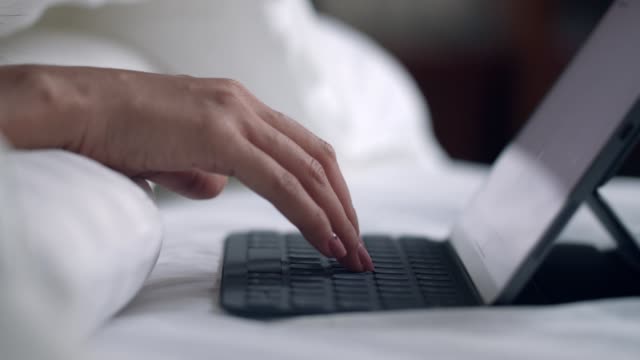 Nahaufnahme-Hände-Frau-tippen-auf-einer-Tastatur-mit-einem-Tablet-auf-dem-Schlafzimmer-Surfen-Online-Social-Media-Sharing-Lifestyle.