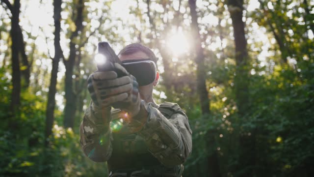 Soldado-apuntando-con-pistola-con-gafas-de-realidad-virtual-al-aire-libre