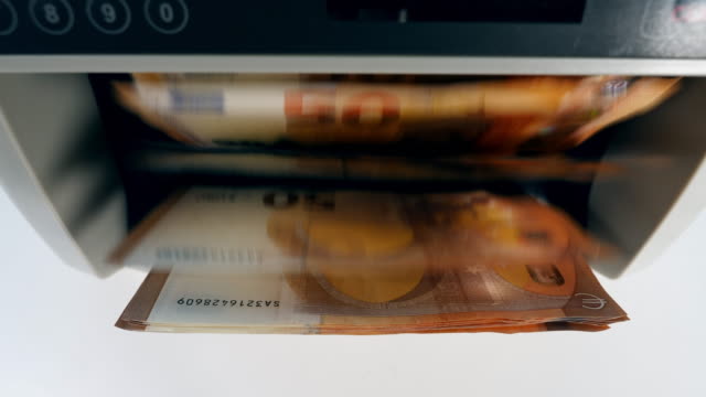 Vista-superior-de-los-billetes-en-euros-dentro-de-la-máquina-de-conteo
