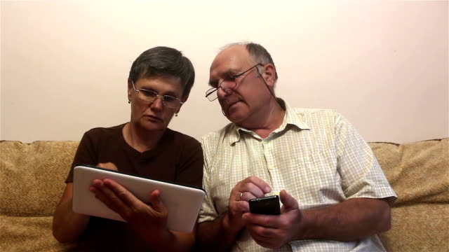 Attraktive-erwachsene-Frau-und-erwachsene-Mann-arbeiten-auf-Tablet-PC-und-Smartphone.