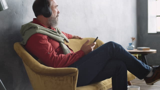 Hombre-sentado-en-el-sofá-y-escuchando-música
