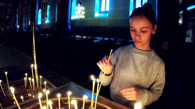Escena-de-Oración-Chica-en-la-Ortodoxia-de-la-Iglesia,-encendiendo-una-vela-y-rezando