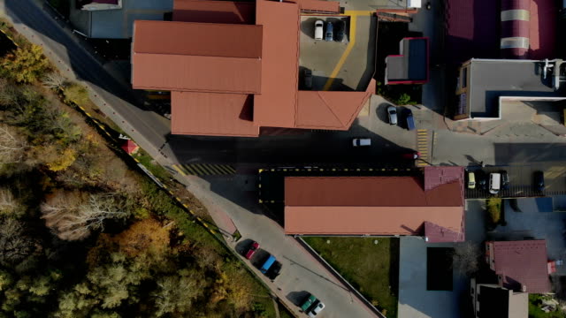 Aerial-Drone-Flight-Top-Ansicht-auf-der-Straße-mit-Häusern-und-Autos,-die-sich-bewegen.-Dächer-von-Häusern-sind-rot-und-Autos,-die-die-Straße-hinunter-bewegen