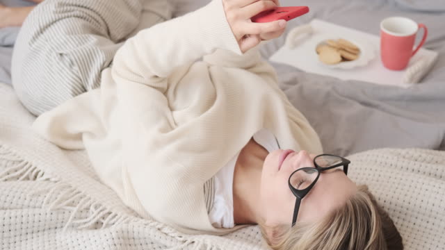 Woman-checking-her-mobile-phone-in-bed