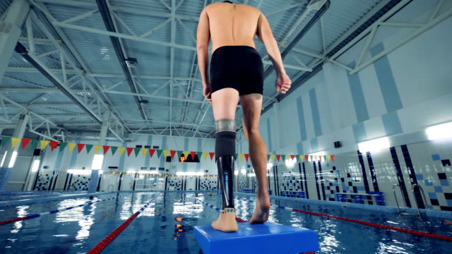 Ein-Mann-mit-einem-bionischen-Bein-wärmt-sich-in-einem-Schwimmbad-auf