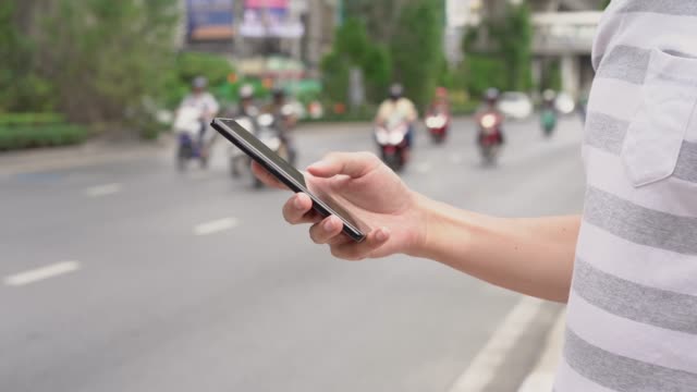 Hand-des-Mannes-mit-einem-Mobiltelefon-auf-der-Straße.-Nutzung-der-Transport-App