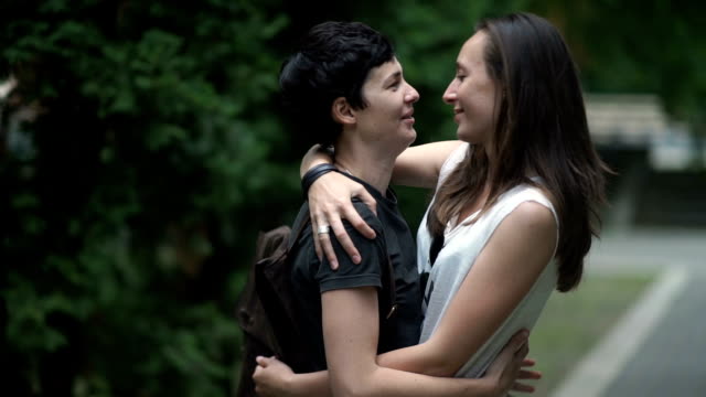 Zwei-glückliche-Lesben-Gespräche,-Umarmungen-und-Küsse-im-park