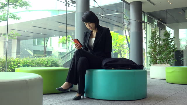 Business-Travel-Asiatische-Frau-Geschäftsfrau-mit-Smartphone-im-Bürogebäude