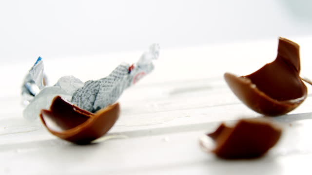 Broken-chocolate-Easter-eggs-falling-on-wooden-surface