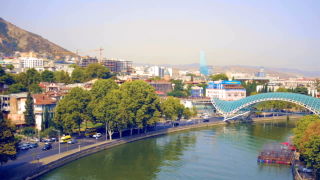 TBILISI,-GEORGIA-capital-of-Georgia.-Aerial-view-of-center-of-Tbilisi,-bridge-of-peace-over-river-Kura.-Camera-flies-on-drone-above-city.