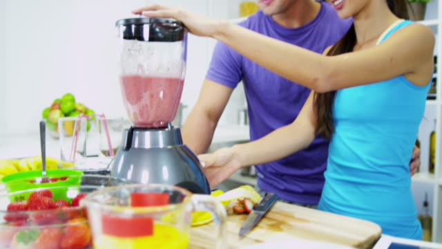 Ethnic-male-female-using-kitchen-blender-fresh-juice
