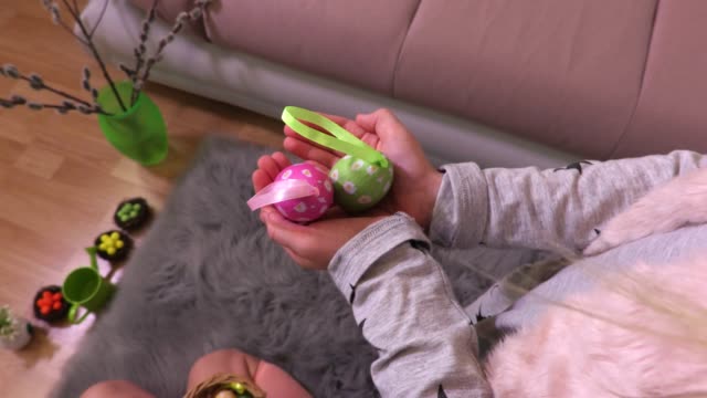 Niña-manteniendo-decorativo-Pascua-huevos