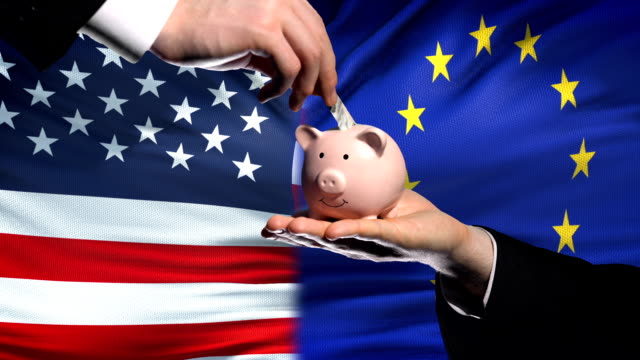 US-Investitionen-in-EU,-Hand,-Geld-im-Sparschwein-auf-Flagge-Hintergrund,-Finanzen